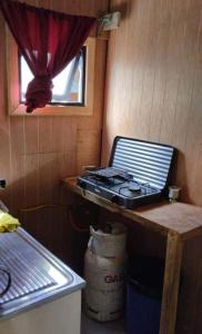 a stove sitting on a table in a small room at Suite doble Coñaripe in Coñaripe