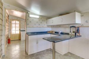 a kitchen with white cabinets and a blue counter top at CasaLago y Tinaja in Puerto Varas