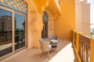 d'un balcon avec deux chaises et une table. dans l'établissement SIMPLY COMFORT in Sarai Palm Jumeirah, à Dubaï