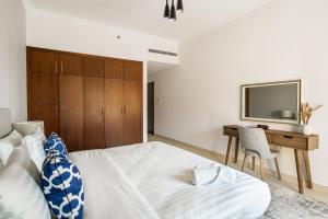- une chambre avec un lit, un bureau et une télévision dans l'établissement SIMPLY COMFORT in Sarai Palm Jumeirah, à Dubaï