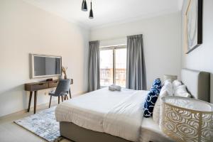 a bedroom with a bed and a desk and a television at SIMPLY COMFORT in Sarai Palm Jumeirah in Dubai