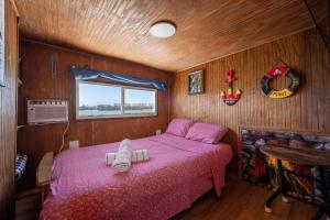 Beautiful Houseboat in Key West في كي ويست: غرفة نوم مع سرير وردي في قارب