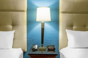 una lámpara y un teléfono en una mesa entre dos camas en Baymont by Wyndham McAllen Pharr, en McAllen