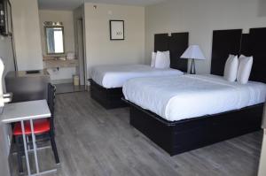 Habitación de hotel con 2 camas, mesa y silla en My Home & Suites Covington en Covington