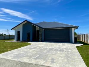 a house with a garage in a yard at Style, Functional with Space in Twizel