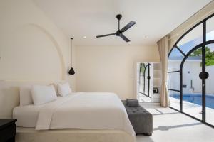 a bedroom with a bed and a large window at The Grand Daha Luxury Villas in Seminyak