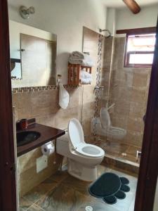 y baño con aseo, lavabo y ducha. en Hotel El Peregrino De La Villa en Villa de Leyva
