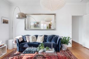 a living room with a blue couch and a mirror at CHES4 - Woollahra Getaway in Sydney