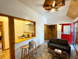 Una sala de estar con un sofá y una cocina. en Boulder Bay Cottages, en Big Bear Lake