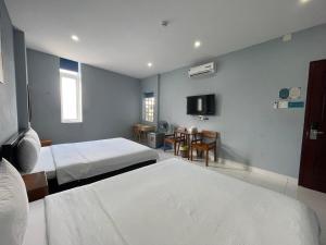 a hotel room with two beds and a television at An Nhiên Hotel in Tây Ninh