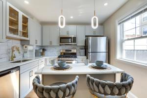 a kitchen with white cabinets and a island with two chairs at Philadelphia Vacation Rental about 4 Mi to Center City in Philadelphia