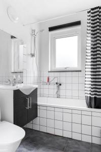 un bagno bianco con vasca e lavandino di Fint boende nära Isaberg Mountain Resort a Grimsås