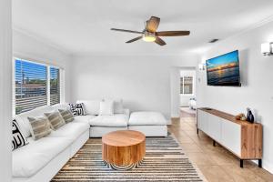 a living room with a white couch and a ceiling fan at Serenity Retreat Pool BBQ Swing Set WiFi+ in West Palm Beach
