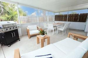 a patio with a grill and a table and chairs at Serenity Retreat Pool BBQ Swing Set WiFi+ in West Palm Beach