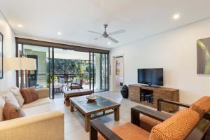 un soggiorno arredato con TV a schermo piatto di Temple Resort & Spa Port Douglas a Port Douglas