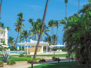 a resort with palm trees and a pool at Oceanfront Playa Turquesa with highspeed Wi-Fi, pools, free beach access in Punta Cana