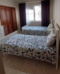 a bedroom with two beds and a window at Oceanfront Playa Turquesa with highspeed Wi-Fi, pools, free beach access in Punta Cana