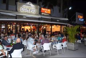 a group of people sitting at tables outside a restaurant at Oceanfront Playa Turquesa with highspeed Wi-Fi, pools, free beach access in Punta Cana