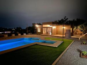 GranizoにあるCabaña en Olmue con piscina compartidaの夜の庭にスイミングプールがある家