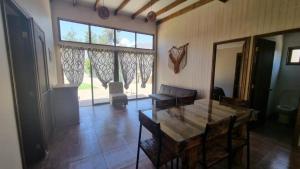 a living room with a table and a large window at Cabaña en Olmue con piscina compartida in Granizo