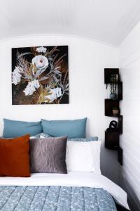 a bedroom with a bed with a picture on the wall at Rustic Rails Accommodation in Dargaville