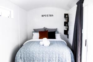 a bedroom with a bed with a teddy bear on it at Rustic Rails Accommodation in Dargaville