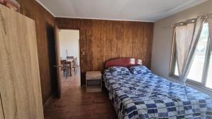 1 dormitorio con cama, ventana y mesa en Cabaña en Olmue con piscina compartida en Granizo
