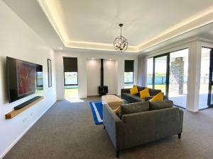 sala de estar con 2 sofás y TV en Style, Functional with Space, en Twizel