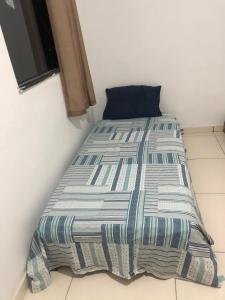 a bed in a corner of a room at Tchê Hostel in Porto Seguro