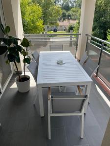 a white table and chairs on a balcony at L' appart de Chantal in Lherm