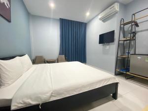 Habitación hospitalaria con cama y TV en An Nhiên Hotel, en Tây Ninh
