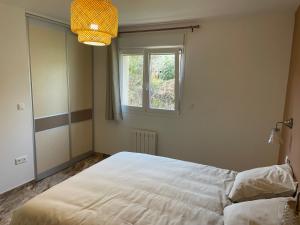 a bedroom with a large white bed and a window at L' appart de Chantal in Lherm