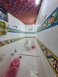 a bathroom with a toilet and a ceiling with sprinkles at Rann bhumi village resort in Bherandiāla