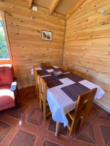 ein Esszimmer mit einem Tisch und Stühlen in einer Hütte in der Unterkunft CABAÑAS RUCA MALAL in Futrono