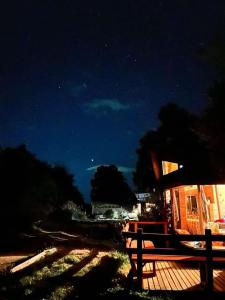 a wooden bench sitting on a deck at night at CABAÑAS RUCA MALAL in Futrono