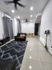 a living room with a black couch and a ceiling fan at MIHI Homestay Pantai Sepat in Kuantan