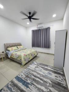 a bedroom with a bed and a ceiling fan at MIHI Homestay Pantai Sepat in Kuantan