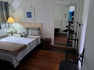um quarto com uma cama e um quarto com um espelho em Sobrado Botafogo no Rio de Janeiro