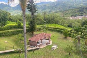 una pequeña casa en un campo con una palmera en Verano eterno entre montañas, 