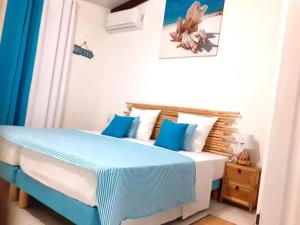 a bedroom with a bed with blue and white sheets at Agréable maison 3 pièces tout confort pour 4 personnes - Vue sur jardin in Saint-François