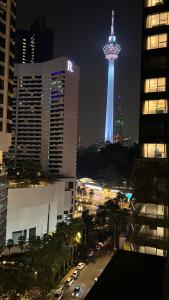 una vista de la aguja del espacio iluminada por la noche en Summer suites near klcc en Kuala Lumpur