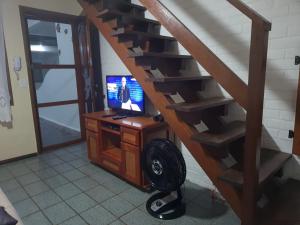 Pokój z klatką schodową, telewizorem i biurkiem w obiekcie CASA PERO CABO FRIO a 60 Metros da praia w mieście Cabo Frio