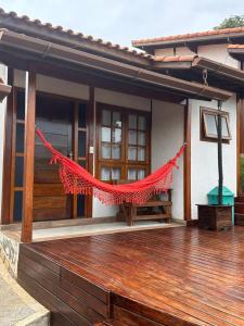 une maison avec un hamac rouge sur une terrasse en bois dans l'établissement Villagio Aguas do Jaguari Pousada, à Santa Isabel