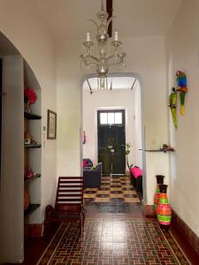 a hallway with a living room with a chandelier at Hostal Rosa Mexicano in Mérida