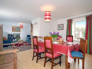 a dining room with a red table and chairs at South Nolton Farmhouse-qc1265 in Nolton