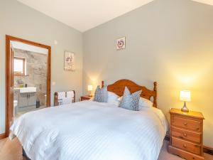 a bedroom with a large white bed with blue pillows at Oak Cottage - Uk45576 in Maltby le Marsh