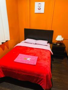 a bedroom with a red bed with a red blanket at KORICANCHA in Lima