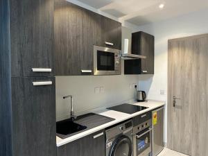 a kitchen with a washing machine and a microwave at Havens Apartment in Accra