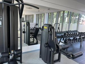 a gym with rows of treadmills and machines at Havens Apartment in Accra