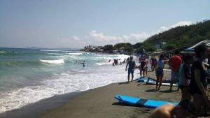 un grupo de personas en una playa con tablas de surf en Manipon Transient House R6, en San Juan